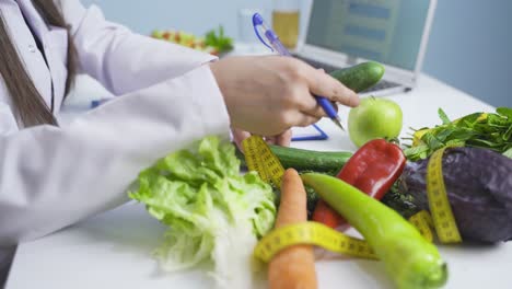 Research-dietitian.-Examines-vegetables-and-takes-notes.